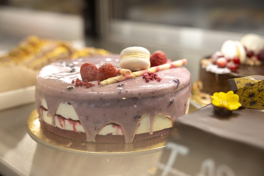 Tort cu glazură de fructe de pădure, zmeură și macaron, în vitrina AROMA